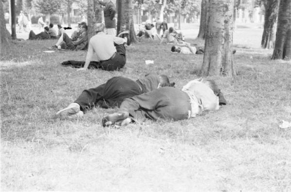 Milano. Parco Sempione. Gruppi di persone sedute a chiacchierare o sdraiate a riposare sull'erba
