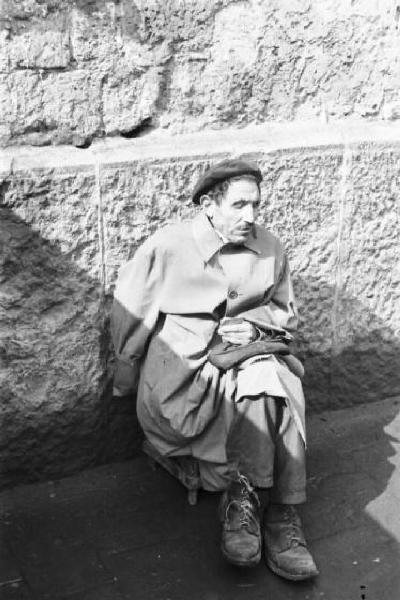 Italia Dopoguerra. Napoli. Mutilato chiede la carità seduto accanto a un muro