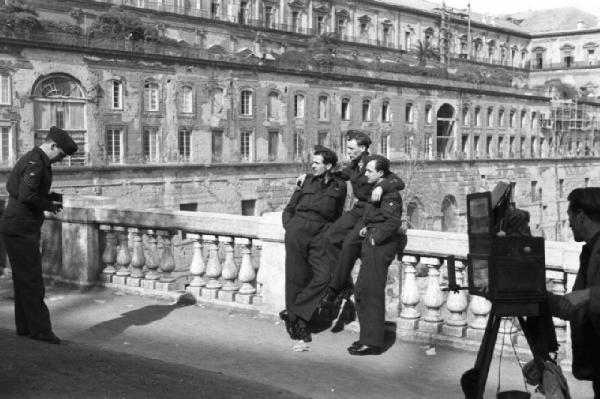 Italia Dopoguerra. Napoli. Un militare scatta una foto ricordo a un gruppo di tre militari. Accanto un fotografo ambulante