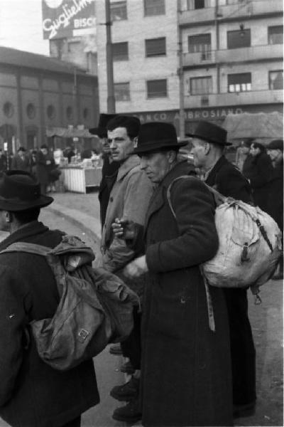 Italia Dopoguerra. Milano. Persone con zaini in attesa di prendere i mezzi pubblici