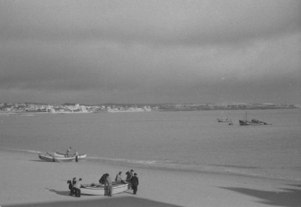 Portogallo. Cascais. Gruppi di pescatori con le barche sulla spiaggia