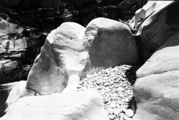Val Verzasca - fotomodella nuda sdraiata all'interno di un massiccio roccioso