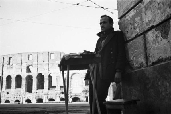 Italia Dopoguerra. Roma. Mercato nero. Vendita di sigarette all'angolo di una strada. Sullo sfondo il Colosseo