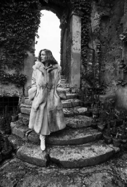 Fotomodella indossa una pelliccia di visone lavorata a pelle intera - Scende una scalinata in pietra