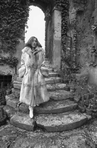 Fotomodella indossa una pelliccia di visone lavorata a pelle intera - Scende una scalinata in pietra