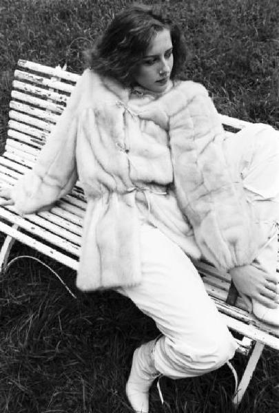 Fotomodella indossa una pelliccia di visone lavorata a pelle intera - Siede su una panchina