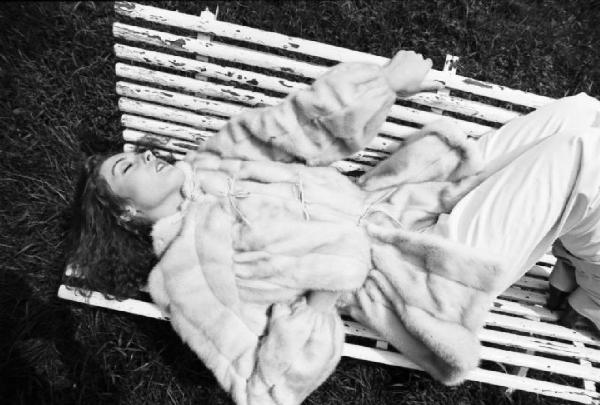 Fotomodella indossa una pelliccia di visone lavorata a pelle intera - Giacca con coulisse in vita - Siede su una panchina