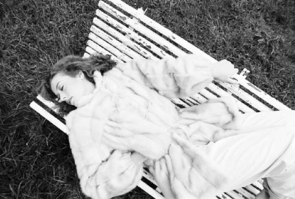 Fotomodella indossa una pelliccia di visone lavorata a pelle intera - Giacca con coulisse in vita - Siede su una panchina