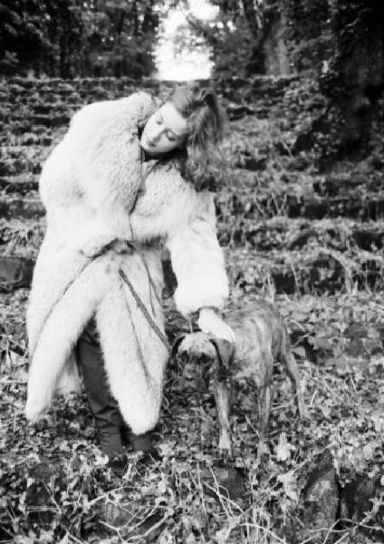 Fotomodella indossa una pelliccia di volpe - Cappotto - Tiene un cane al guinzaglio