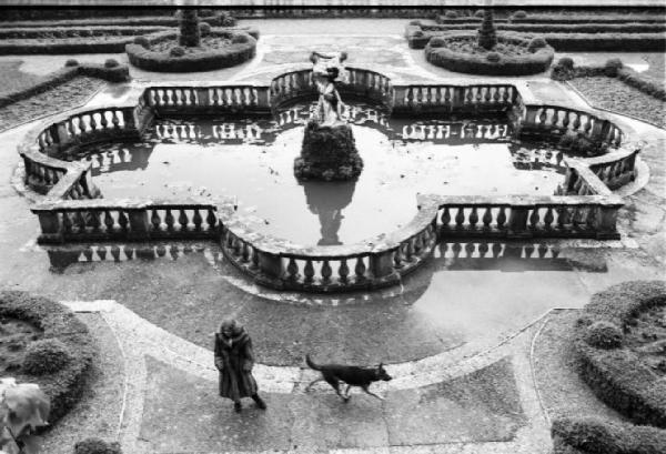 Fotomodella indossa una pelliccia di volpe - Cappotto - Posa nei pressi di una fontana di un giardino storico