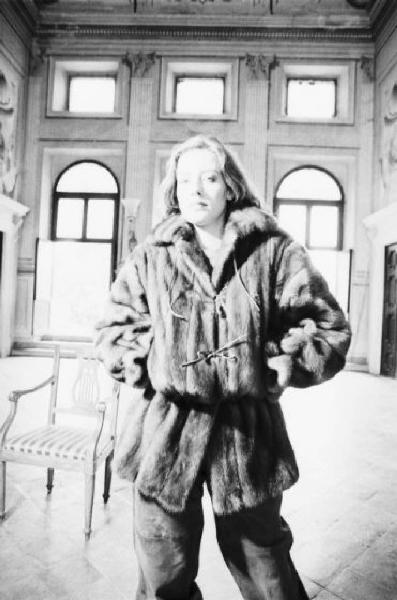 Fotomodella indossa una pelliccia di visone - giacca con coulisse in vita - Posa nel salone di una villa