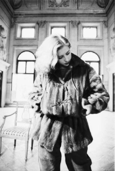 Fotomodella indossa una pelliccia di visone - giacca con coulisse in vita - Posa nel salone di una villa