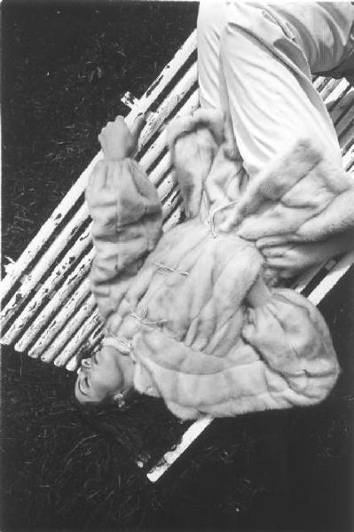 Fotomodella indossa una pelliccia di visone perla - giacca a tre quarti - Posa stesa su una panchina
