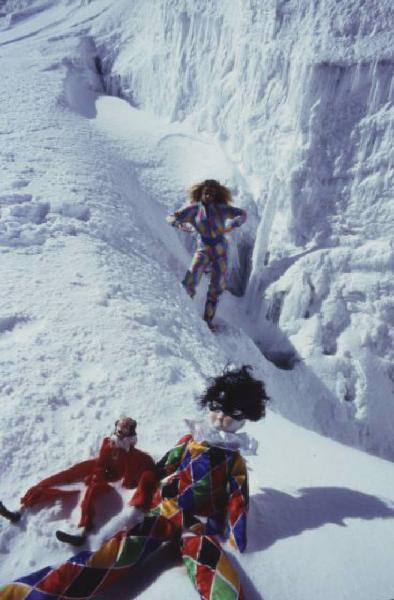 Campagna pubblicitaria Ellesse. Fotomodella indossa tuta da sci arlecchino - neve - fantocci