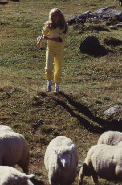 Campagna pubblicitaria Ellesse. Fotomodella indossa tuta da ginnastica gialla - prati di un alpeggio - pecore