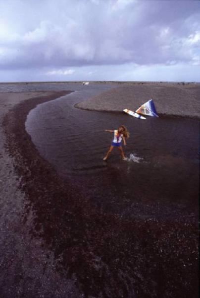 Campagna pubblicitaria Ellesse. Fotomodella indossa una muta - torrente - scarpa da ginnastica - windsurf