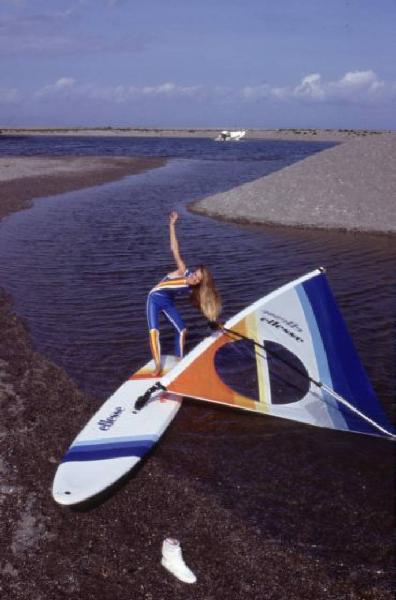 Campagna pubblicitaria Ellesse. Fotomodella indossa una muta - torrente - scarpa da ginnastica - windsurf