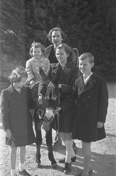 Estoril. Famiglia Savoia in esilio. Ritratto di gruppo - la regina Maria José del Belgio con i figli. Maria Beatrice in groppa a un asinello