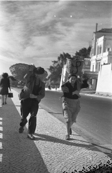 Estoril. Lungomare - persone recano ceste in testa e sulle spalle