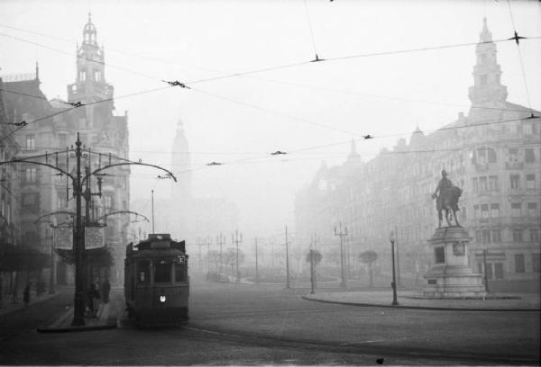 Porto. Viale immerso nella nebbia - tram alla fermata - monumento equestre - palazzi
