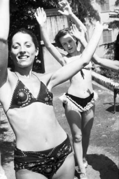 Gruppo di ragazze sorridenti in bikini esegue un ballo