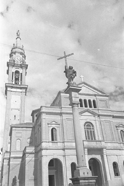 Facciata di una chiesa, campanile e colonna votiva con il Redentore