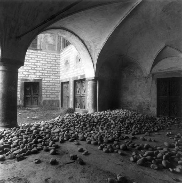 Mazzo di Valtellina - Palazzo Quadrio - Sottoportico - in primo piano pietre sparse a terra - sullo sfondo il cortile interno affrescato