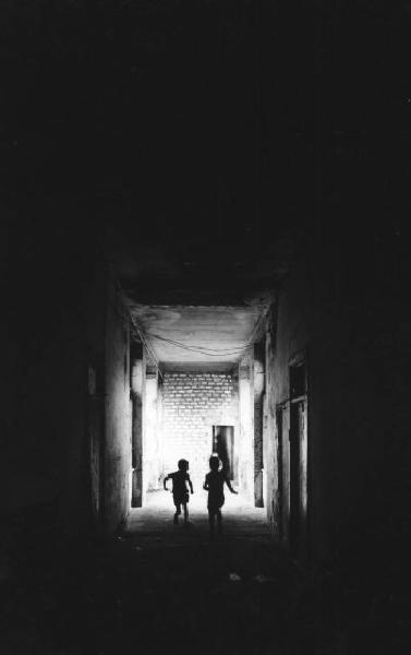 Il ventre del colera. Ercolano - Edificio fatiscente - Due bambini corrono per il corridoi buio