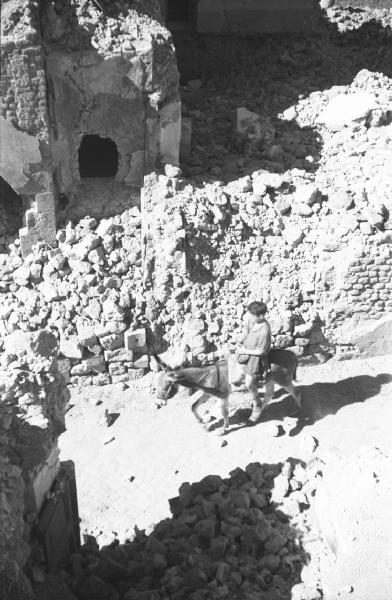 Italia Dopoguerra: Valmontone bombardata. Valmontone - Edifici bombardati - Macerie - Ritratto maschile: ragazzo in sella ad un asino