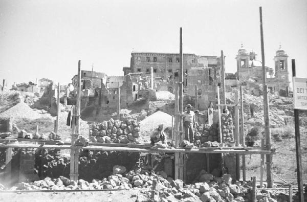 Italia Dopoguerra: Valmontone bombardata. Valmontone - Veduta della città bombardata - Cantiere -Impalcatura - Ritratto maschile: operai al lavoro - Macerie
