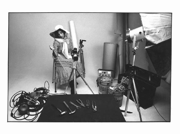 I Ruoli. Ritratto femminile: Liliana Barchiesi fotografa degli utensili - Set fotografico: macchina fotografica con treppiedi, lampada, cavi