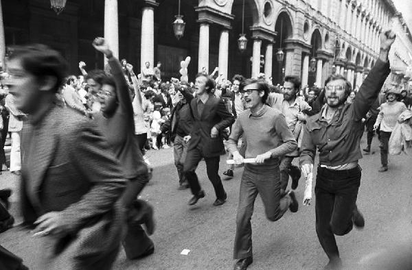 Altrove (1967-1980). Torino, via Roma - Manifestazione - Movimento studentesco - Strada - Giovani che corrono con pugni alzati