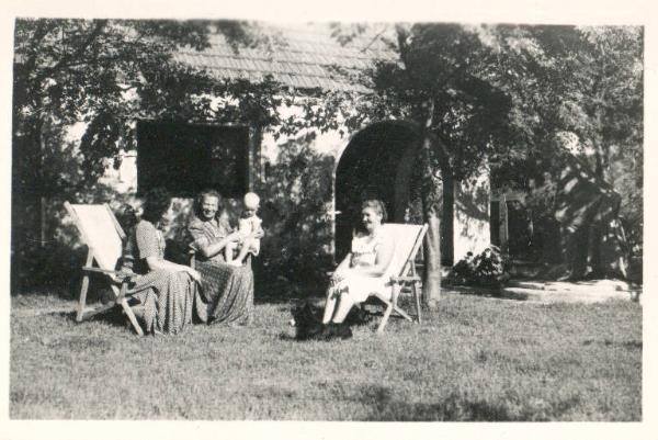 Ritratto di famiglia - Tre donne sedute su sedie a sdraio nel giardino di una villa - Cesarito in braccio a una delle tre signore