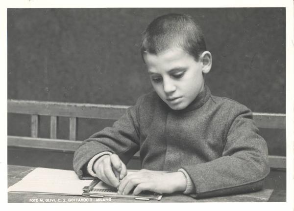 Istituto dei Ciechi di Milano - Scuola elementare - Aula scolastica - Interno - Allievo scrive in Braille con tavoletta metallica e punteruolo
