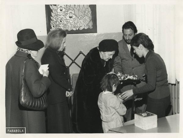 Istituto dei Ciechi di Milano - Visita di benefattori - Interno - Aula - Dame Patronesse consegnano uova di cioccolato a una bambina