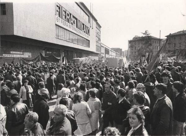 Milano - 61 Fiera Campionaria 1983 - Inaugurazione - Manifestazione di lavoratori metalmeccanici e tessili per il contratto - Presidio davanti a un ingresso della Fiera - Bandiere e cartelli di protesta
