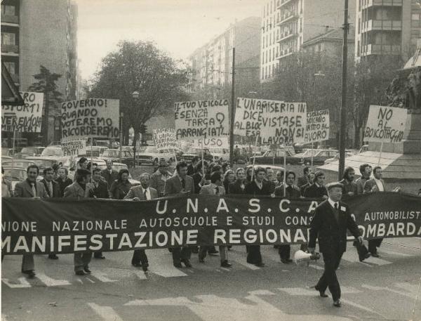 Milano - Sciopero lavoratori delle scuole guida - Corteo con striscione dell'UNASCA - Uomo con megafono - Cartelli