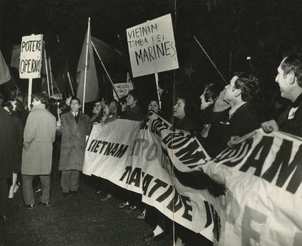 Milano - Manifestazione contro la guerra in Vietnam - Corteo notturno con cartelli di protesta, torce e bandiere