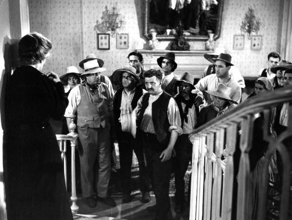 Scena del film "Il padrone sono me" - Regia Franco Brusati - 1955 - L'attrice Andreina Pagnani vestita di nero in casa su una scala. Davanti a lei dei contadini