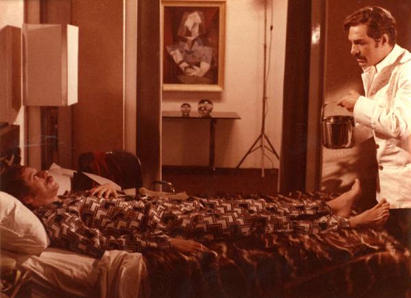 Scena del film "Pane e cioccolata" - Regia Franco Brusati - 1974 - Gli attori Nino Manfredi e Johnny Dorelli, steso sul letto
