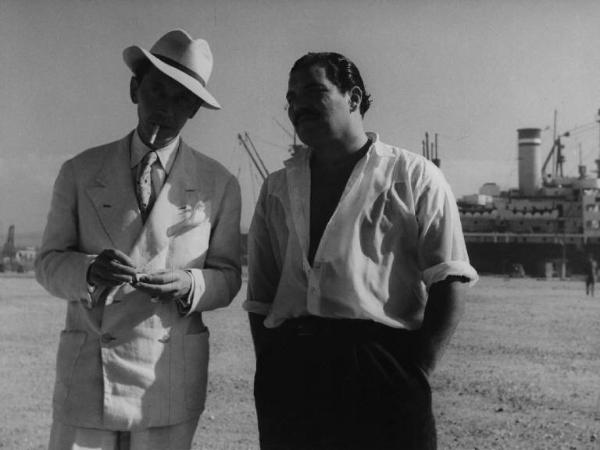 Scena del film "Senza pietà" - Regia Alberto Lattuada - 1948 - Gli attori Folco Lulli e Pierre Claudé con una sigaretta e il cappello