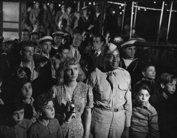 Scena del film "Senza pietà" - Regia Alberto Lattuada - 1948 - Gli attori John Kizmiller e Carla Del Poggio in mezzo alla folla