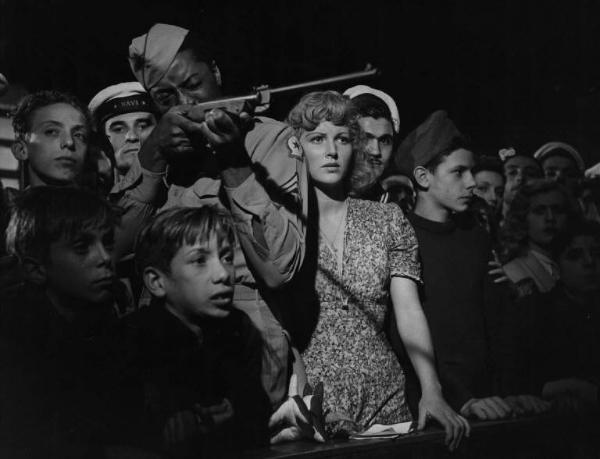 Scena del film "Senza pietà" - Regia Alberto Lattuada - 1948 - Gli attori John Kitzmiller, con un fucile, Carla Del Poggio e un gruppo di attori non identificati