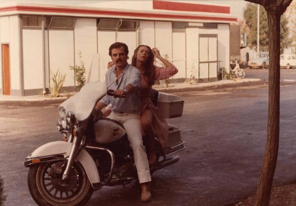 Scena del film "La cicala" - Regia Alberto Lattuada - 1980 - Gli attori Antonello Fassari e Barbara De Rossi in motocicletta