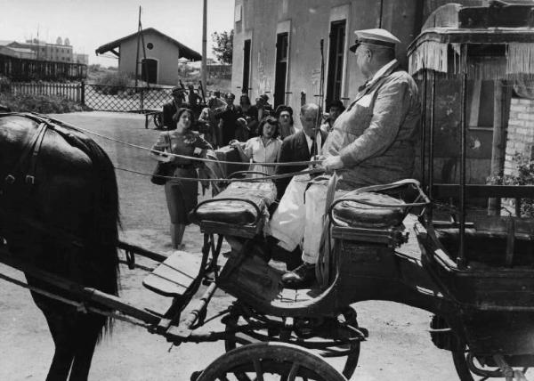 Scena del film "Luci del varietà" - Regia Alberto Lattuada, Federico Fellini - 1950 - Un cocchiere in carrozza in primo piano. Attori non identificati sullo sfondo