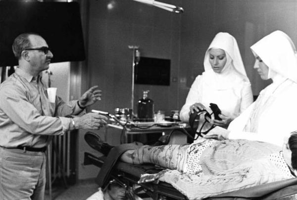 Set del film "Bianco, rosso e..." - Regia Alberto Lattuada - 1972 - Il regista Alberto Lattuada con l'attrice Sophia Loren in abito da suora e due attori non identificati