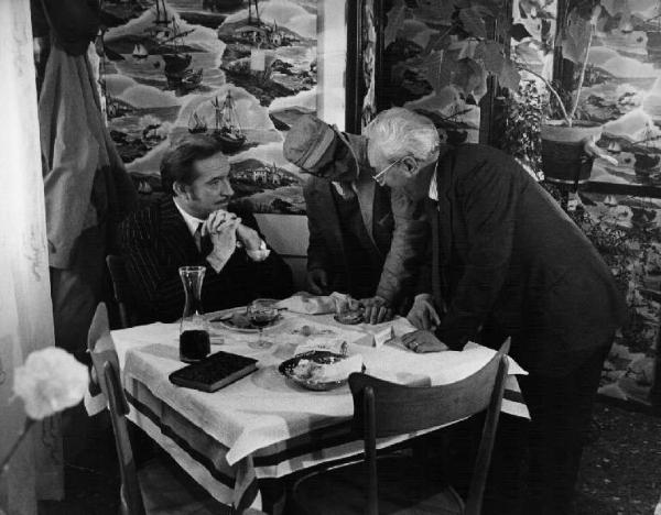 Set del film "Venga a prendere il caffè... da noi" - Regia Alberto Lattuada - 1970 - Il regista Alberto Lattuada e l'attore Ugo Tognazzi a tavola con un attore non identificato