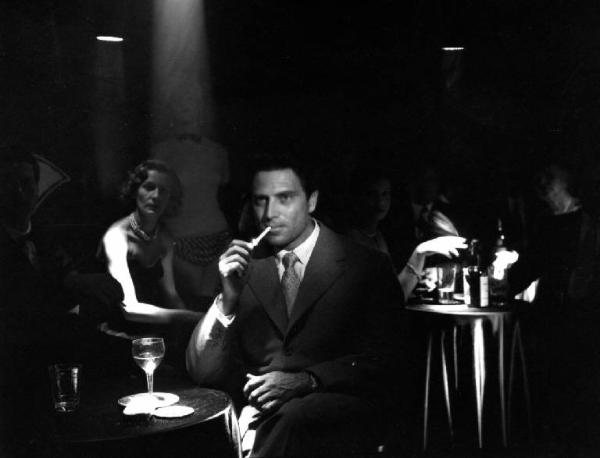 Scena del film "Anna" - Regia Alberto Lattuada - 1951 - L'attore Raf Vallone con una sigaretta seduto a un tavolo di un locale
