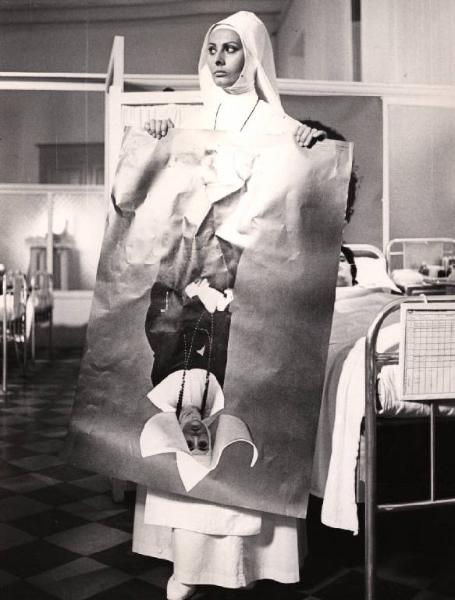 Scena del film "Bianco, rosso e..." - Regia Alberto Lattuada - 1972 - L'attrice Sophia Loren, in abito da suora infermiera, in ospedale tiene in mano un poster