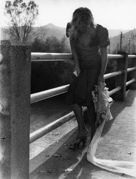 Scena del film "La cicala" - Regia Alberto Lattuada - 1980 - L'attrice Virna Lisi con un foglio in mano su un ponte